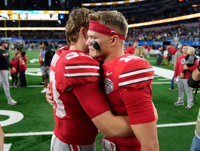 Dec 29, 2023; Arlington, TX, USA; Ohio State Buckeyes quarterback Devin Brown (33) hugs Ohio State Buckeyes quarterback Lincoln Kienholz (12) after losing 14-3 to Missouri Tigers in the Goodyear Cotton Bowl Classic at AT&T Stadium.
